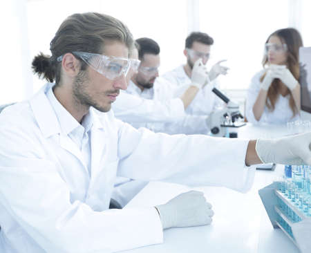 Scientists working with a microscope and make notes in the workplace