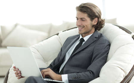 close-up of smiling businesswoman working with laptop in living room.の写真素材