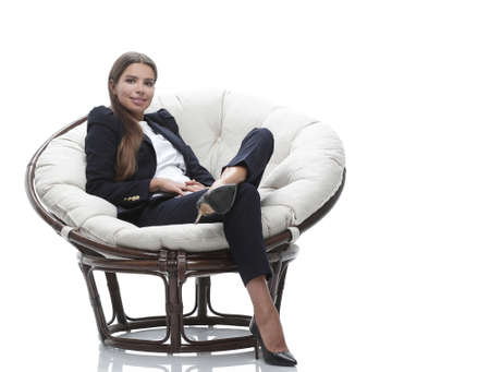 young business woman relaxes in a round chairの写真素材