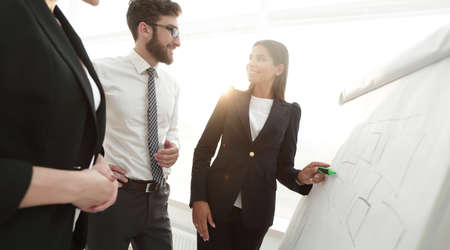 businesswoman pointing marker to flipboard on presentation in office