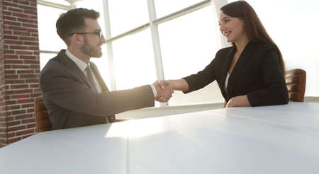 Friendly smiling business people  handshaking after pleasant tal
