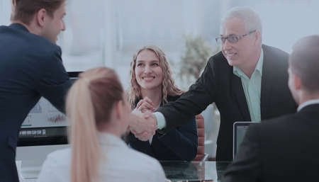 Business partners shaking hands after a successful transaction.