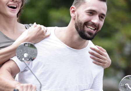 Cool man and beautiful girl riding on  scooter with  expressionの写真素材