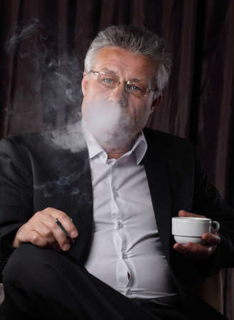 senior businessman drinking coffee and Smoking,sitting in the chair.の写真素材