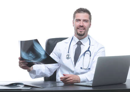 doctor examines an x-ray,sitting behind a Deskの写真素材