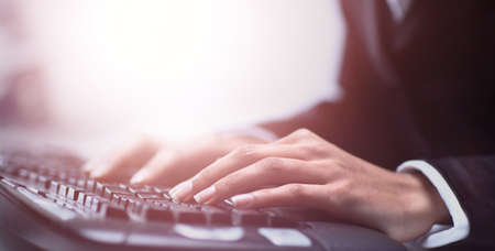 Female hands typing on computer keyboardの写真素材