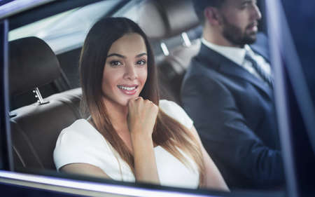 Portrait of a woman in a white dress in her car in the back seat