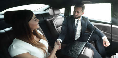 man and woman shaking hands in car