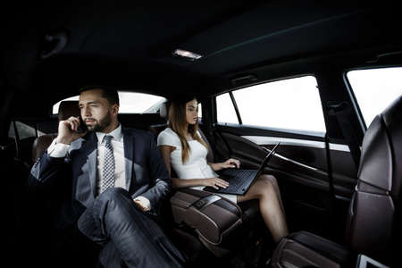 business people using mobile phones and laptop during a trip