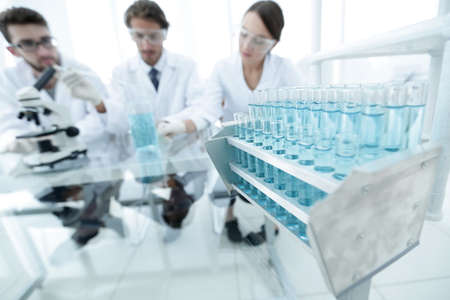 background image of scientists studying blue liquid in a flaskの写真素材