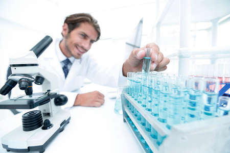 Chemist looking at test-tubes with blue liquids