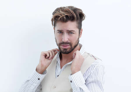 A man adjusts the collar of a white shirtの写真素材