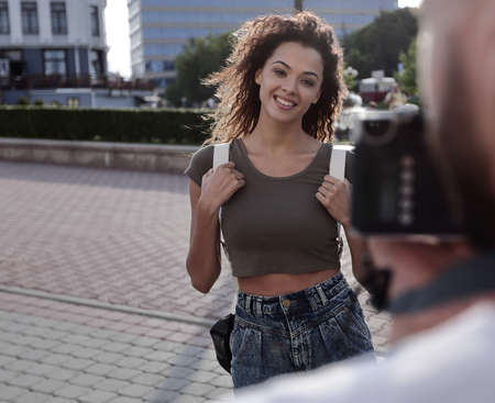 Beautiful brown curly hair  woman posing in city