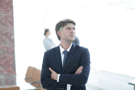 confident businessman stands and looks away.の写真素材