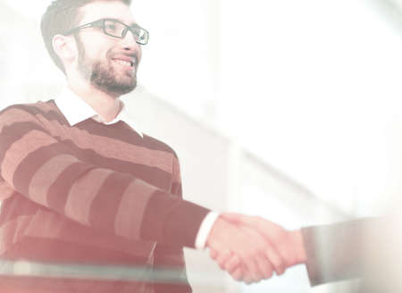 Business people closing a deal and handshaking at the officeの写真素材