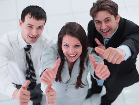 Business colleagues looking at camera and shoving thumbs up in tの写真素材