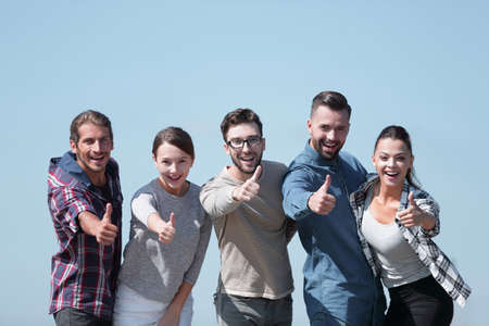 smiling group of young people showing thumb up.の写真素材