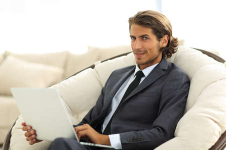 close-up of smiling businesswoman working with laptop in living room.の写真素材