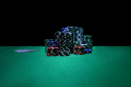 gambling, fortune, game and entertainment concept - close up of casino chips on green table surfaceの写真素材