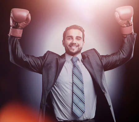 Businessman in a suit and boxing gloves, celebrating a winの写真素材