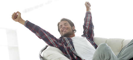 stylish guy stretching in a comfortable chairの写真素材