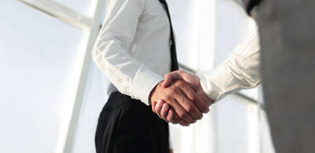 Closeup of a business handshake, on bright  backgroundの写真素材