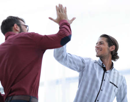 two business men giving each other a high five.の写真素材