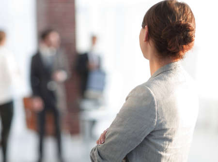 rear view of business woman on blurred background office.の写真素材