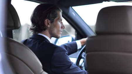 successful man sitting behind the wheel of a carの写真素材