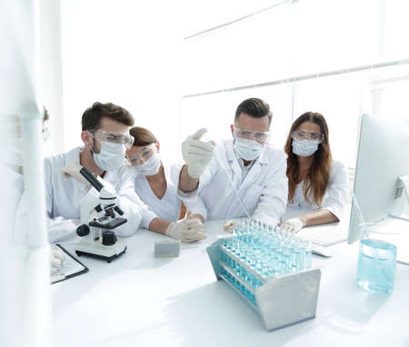 medical doctors are working with test tubes and microscope at the labの写真素材