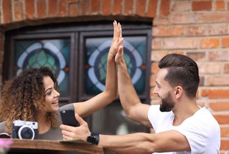 Portrait of a young  couple sitting down at a cafe terraceの写真素材