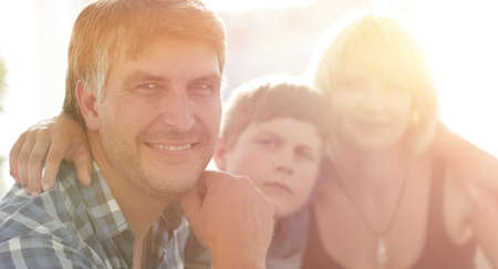 family with two children sitting together and looking at cameraの写真素材