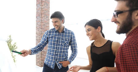 happy man in checkered shirt standing in office near flipchart