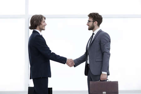 Two young businessmen greet