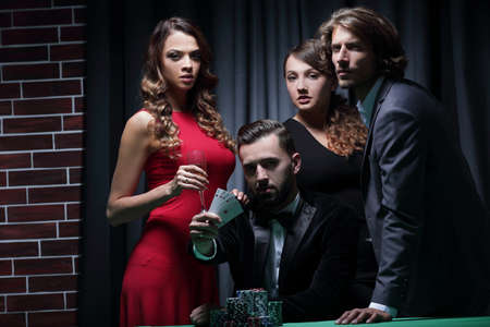 adult group celebrates a friends victory in pokerの写真素材