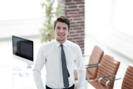 confident young businessman on background of officeの写真素材