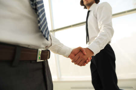 Closeup of a business handshake, on bright  background