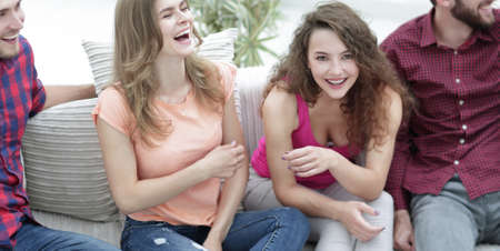 cheerful friends laughing in the living room.の写真素材