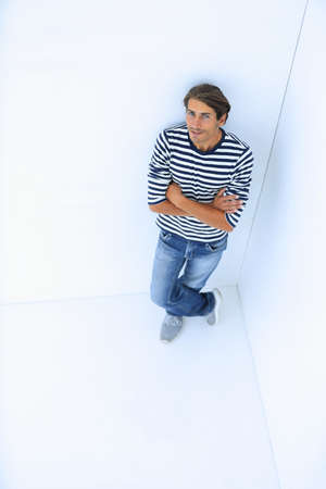 handsome guy standing near the white wallの写真素材