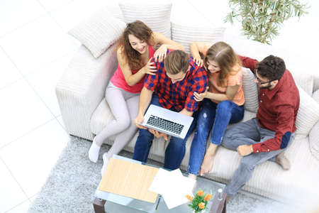 cheerful group of friends looking at the video clips on the laptop.の写真素材