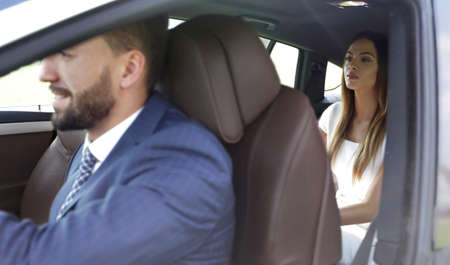 Handsome bearded businessman is sitting in a new car