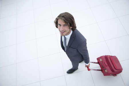 smiling businesswoman with travel suitcase