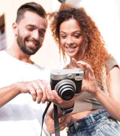 Portrait of young friends walking looking at the photos