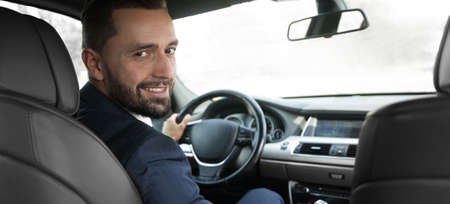businessman sitting at the wheel of a prestigious car