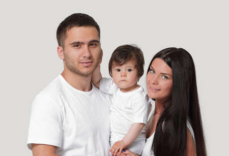 Happy family with newborn baby on a white background.の写真素材