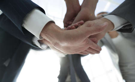 business people folding their hands together.