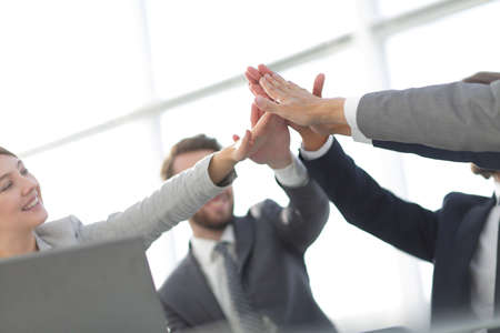 happy business team giving high five in officeの写真素材