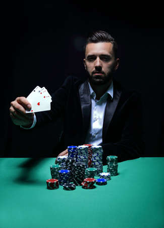 Happy poker player winning and holding a pair of acesの写真素材