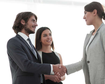 Businesspeople  shaking hands against room with large window looの写真素材