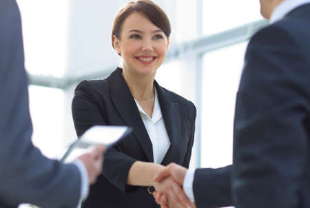 Businesswoman shaking hands with a businssman during a meeting